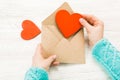 Hand of girl writing love letter on Saint Valentines Day. Handmade postcard with red heart shaped figure. 14 February holiday Royalty Free Stock Photo