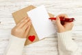 Hand of girl writing love letter on Valentine Day. Handmade postcard. Woman write on postcard for 14 February holiday celebration. Royalty Free Stock Photo