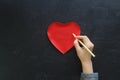 Hand of girl writing love letter on Valentine Day. Handmade red heart postcard. Woman write on postcard for 14 February holiday ce Royalty Free Stock Photo