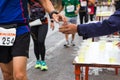 Hand give Minerals water to Unidentified runners Royalty Free Stock Photo