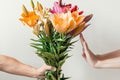 Hand gives bouquet of lilies flowers to girl and receives refusal, woman refuses and shows stop sign