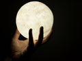 Hand giving away the moon