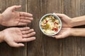 hand giving bowl food needy person. High quality photo Royalty Free Stock Photo