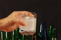 Hand with a glass of water and effervescent pill of a hangover on dark background. Royalty Free Stock Photo