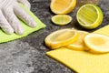 A hand with glove is cleaning the table with lemon biological cleaning agents