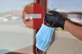 Hand with glove holding face mask in front of forbidden entry sign Royalty Free Stock Photo