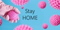 Hand in glove holding model cell virus Covid-19. Banner with text - STAY HOME