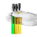 Hand in glove holding test tubes with color samples on white background Royalty Free Stock Photo