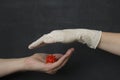 Hand without a glove holds dangerous red coronavirus, hand in white medical disposable rubber latex glove closes, destroys virus, Royalty Free Stock Photo