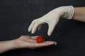 Hand without a glove holds dangerous red coronavirus, hand in white medical disposable rubber latex glove closes, destroys virus, Royalty Free Stock Photo