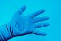 Hand in glove holds invisible dental braces on blue background. Plastic braces dentistry retainers to straighten teeth
