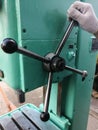 Hand in glove holds iron lever of drilling machine