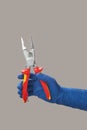 Hand in glove holds open electrician pliers Royalty Free Stock Photo