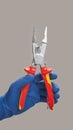 Hand in glove holds open pliers electrician Royalty Free Stock Photo