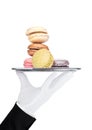 Hand with glove holds tray with sweet macarons
