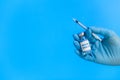Hand in glove holds a vaccine and a syringe Royalty Free Stock Photo
