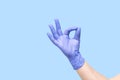 Hand in glove isolated on blue background. Symbol OK. Everything is good. All right. Okey. Okay. Very good. A little bit. You`re