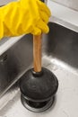 Hand in glove with plunger Royalty Free Stock Photo