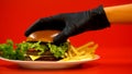 Hand in glove putting bun on hamburger, chef preparing meal, checking quality Royalty Free Stock Photo