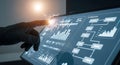 Hand in glove touching futuristic touchscreen displaying financial data and flowcharts Royalty Free Stock Photo