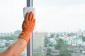 Hand in gloves cleaning window with rag and cleanser spray at ho Royalty Free Stock Photo