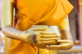 Hand of golden buddha statue holding alms bowl