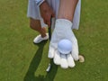 Hand golf glove with white golf ball on green background Royalty Free Stock Photo