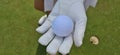 Hand golf glove with white golf ball on green background Royalty Free Stock Photo