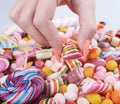 Hand grabbing candy from pile - Overweight problem concept Royalty Free Stock Photo