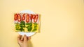 Hand grabs a white plate of four rectangular sandwiches with cheese, ham, paprika, and green arugula from whole grain crisps Royalty Free Stock Photo