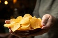 Hand grasping potato chips, ready for a delicious snacking experience