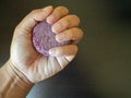 Hand grasping a red Shampoo bar before washing their hair in the shower version 1 Royalty Free Stock Photo