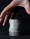 Hand grasping for a stack of silver coins Royalty Free Stock Photo