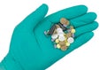 Hand in green glove holding pills Royalty Free Stock Photo