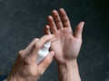 A hand in a green medical glove applying a disinfectant or antiseptic gel to protect against infectious coronavirus Covid-19,