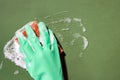 Hand in green rubber glove scrubbing with a sponge and foam Royalty Free Stock Photo