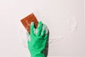 Hand in green rubber glove wiping a foam on the glass, spring cleaning Royalty Free Stock Photo