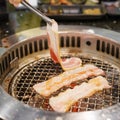 Hand Grilling meat pork on stove serve in restaurant. Japanese food and Korean BBQ traditional style Royalty Free Stock Photo