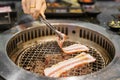 Hand Grilling meat pork on stove serve in restaurant. Japanese food and Korean BBQ traditional style Royalty Free Stock Photo