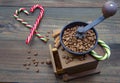 Hand grinder and Christmas candy on a wooden background Royalty Free Stock Photo