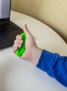 Hand gripper. Man squeezes rubber expander while working on his laptop. Concept of combining useful activity with necessary work. Royalty Free Stock Photo