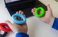 Hand gripper. Man squeezes rubber expander while working on his laptop. Concept of combining useful activity with necessary work. Royalty Free Stock Photo