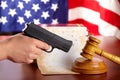 Hand with gun and judges gavel Royalty Free Stock Photo