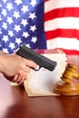 Hand with gun and judges gavel - Vertical