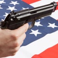 Hand gun over ruffled national flag - United States Royalty Free Stock Photo