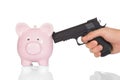 Hand with gun pointing at piggy bank Royalty Free Stock Photo