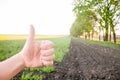 Hand of a guy showing a laik outdoors in a field