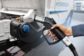 Hand with H2 fueling nozzle on a background of hydrogen fuel cell truck. Eco-friendly commercial vehicle concept Royalty Free Stock Photo