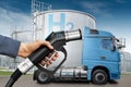 Hand with H2 fueling nozzle on a background of hydrogen truck Royalty Free Stock Photo