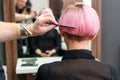 Hand of hairdresser is combing a client's short pink hair with a comb. Royalty Free Stock Photo